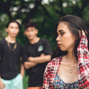 a girl looking behind her at two boys following her